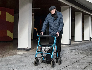 Elderly person walking with mobility aid